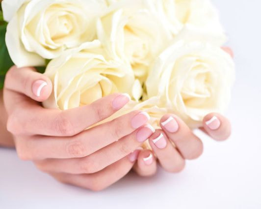 プレミアムフラワープランのイメージ|白いバラを両手に抱える華やかな献花